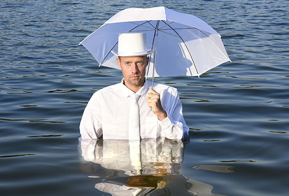 staged art photography, a man with an umbrella in the water